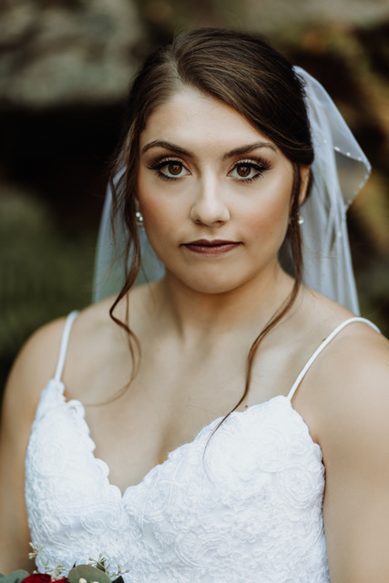 Bride with dark features looks straight ahead.
